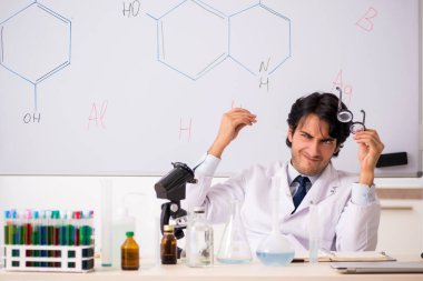 Beyaz tahta önünde genç komik kimyager 