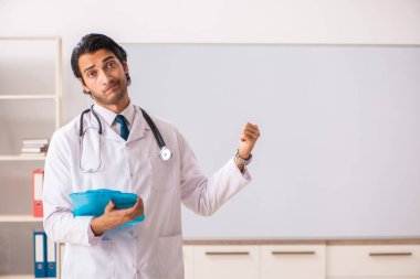 Genç doktor beyaz tahtanın önünde. 