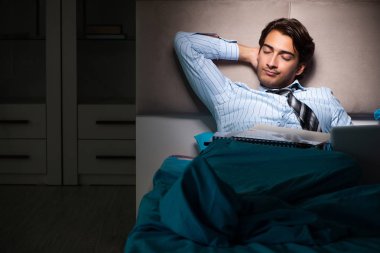Yorgun işadamı gece fazla mesai yapıyor.