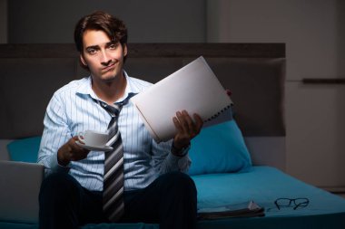 Yorgun işadamı gece fazla mesai yapıyor.