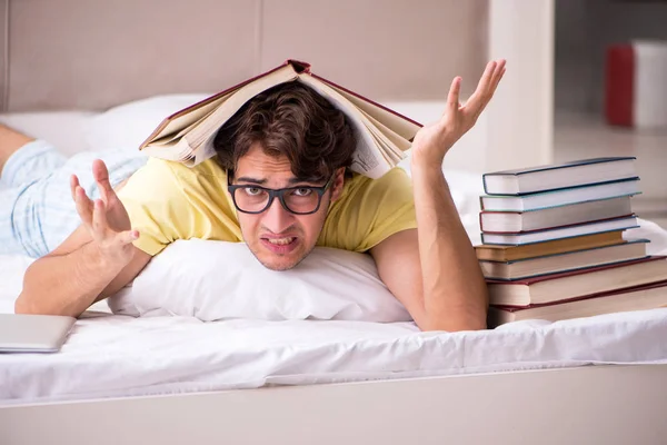 Giovane studente che studia a letto per gli esami — Foto Stock