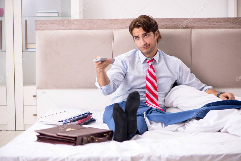 Young employee working at home sitting on the bed 