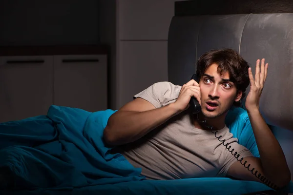 Giovane uomo che parla al telefono a letto — Foto Stock