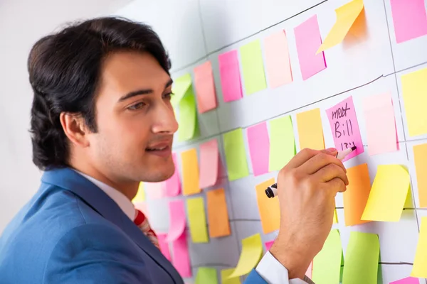 Joven empleado guapo con muchas prioridades contradictorias —  Fotos de Stock