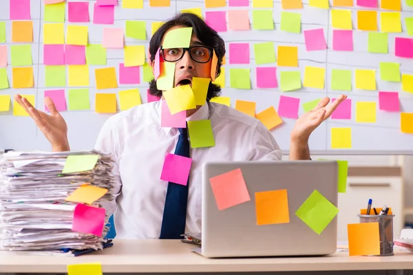 Young employee in conflicting priorities concept — Stock Photo, Image