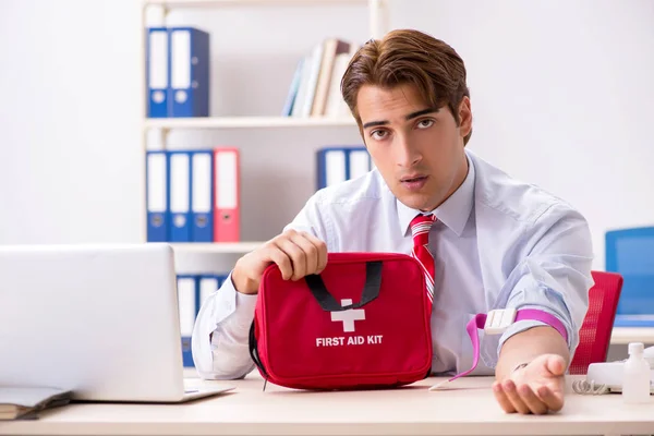 Mann mit Verbandskasten im Büro — Stockfoto