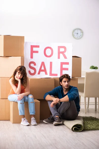 Joven familia ofreciendo casa para la venta y mudanza — Foto de Stock