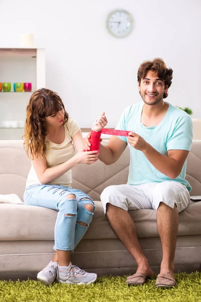 Familia joven ayudándose mutuamente después de una lesión — Foto de Stock