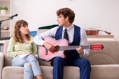 Erkek öğretmenle müzik dersinde genç bir kadın.