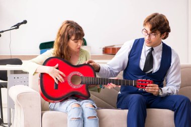 Erkek öğretmenle müzik dersinde genç bir kadın.