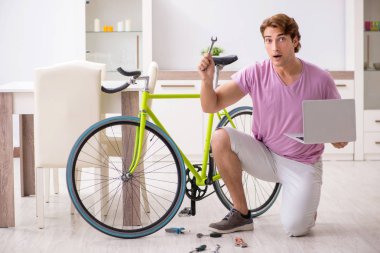 Kırık bisikletini tamir eden adam.