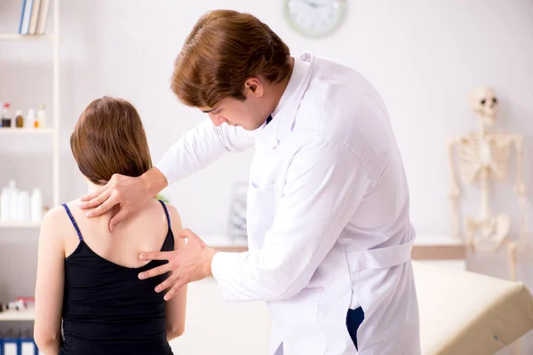 Paciente femenina que visita al joven guapo doctor quiropráctico — Foto de Stock