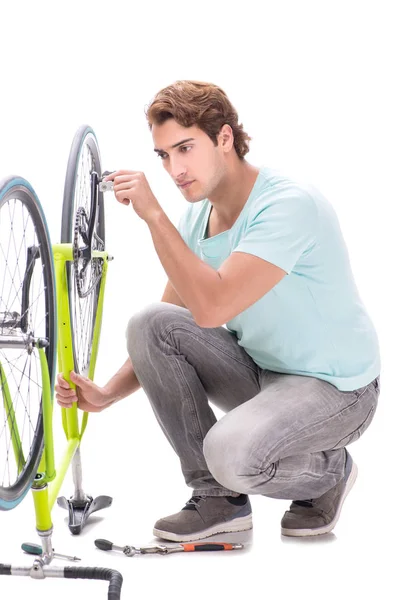 Homem reparando sua bicicleta isolada no fundo branco — Fotografia de Stock