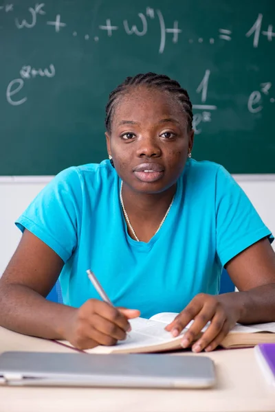 Black female student in front of chalkboard — Stock Photo, Image