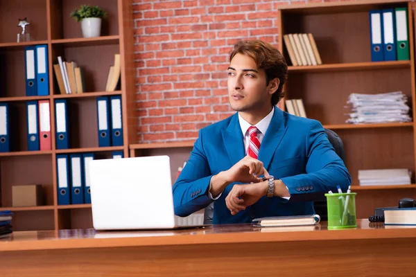 Joven empleado guapo sentado en la oficina — Foto de Stock