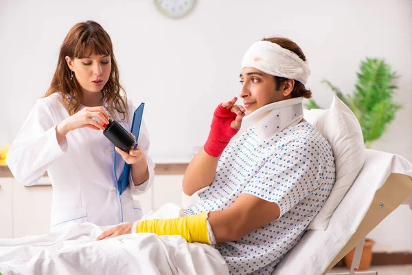 Giovane medico visitante paziente ferito — Foto Stock