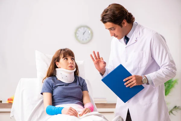 Jovem médico examinando paciente ferido — Fotografia de Stock