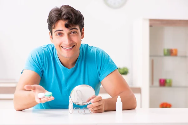 Hombre tratando de lentes de contacto en casa —  Fotos de Stock