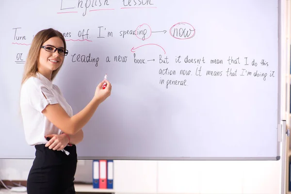 Jonge vrouwelijke Engels leraar staande voor de b — Stockfoto