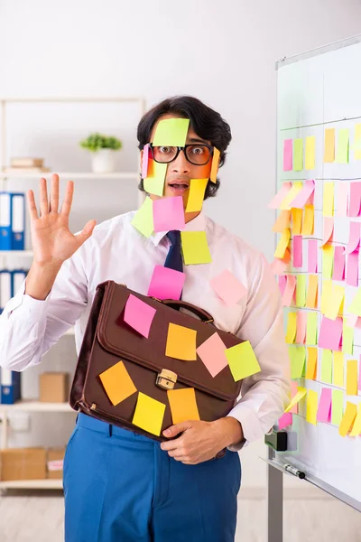 Young employee in conflicting priorities concept — Stock Photo, Image