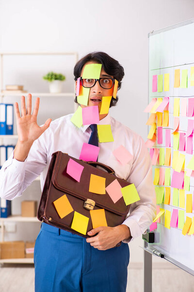 Young employee in conflicting priorities concept 