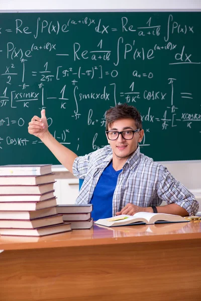 Ung manlig student som studerar matematik i skolan — Stockfoto