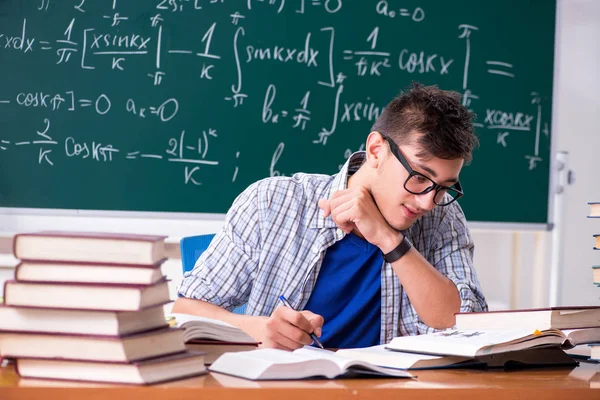 Jonge mannelijke student studeert wiskunde op school — Stockfoto