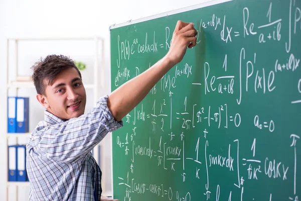 Jonge mannelijke student studeert wiskunde op school — Stockfoto