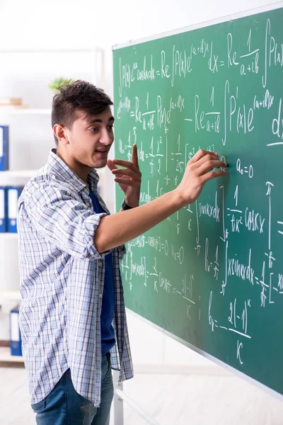 Ung manlig student som studerar matematik i skolan — Stockfoto