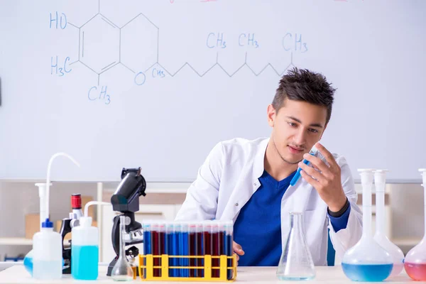 Joven químico sentado en el laboratorio — Foto de Stock