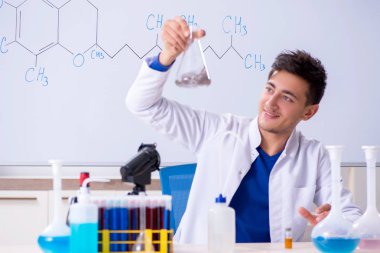 Laboratuarda oturan genç kimyager 