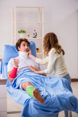 Hastanede yaralı kocayla ilgilenen sevgili bir eş. 