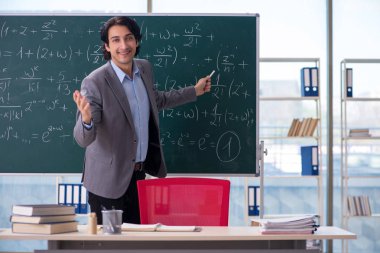 Genç yakışıklı matematik öğretmeni sınıfta 