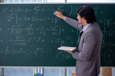 Genç yakışıklı matematik öğretmeni sınıfta 