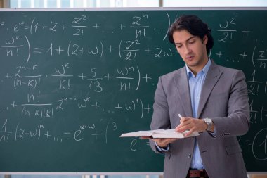 Genç yakışıklı matematik öğretmeni sınıfta 