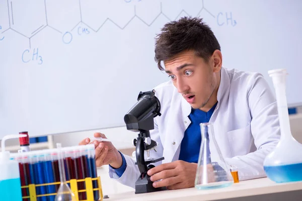 Jovem químico sentado no laboratório — Fotografia de Stock