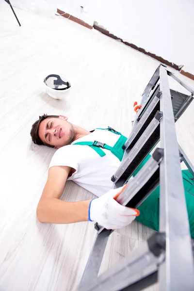 Junger Arbeiter stürzt von Leiter — Stockfoto