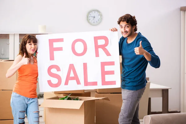 Joven familia ofreciendo casa para la venta y mudanza — Foto de Stock
