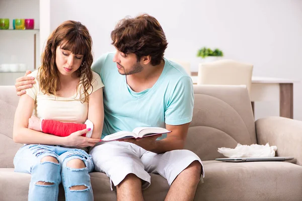 Familia joven ayudándose mutuamente después de una lesión — Foto de Stock