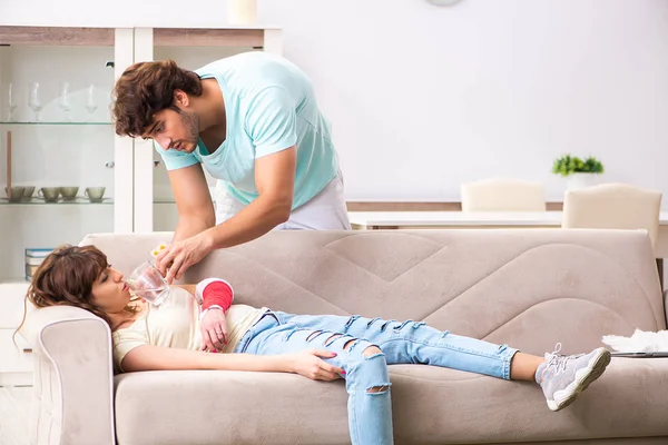 Familia joven ayudándose mutuamente después de una lesión — Foto de Stock