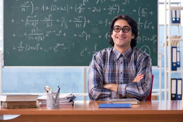 Молодой забавный учитель математики перед доской — стоковое фото
