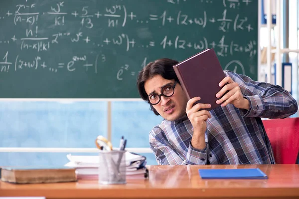 Joven profesor de matemáticas divertido delante de pizarra — Foto de Stock