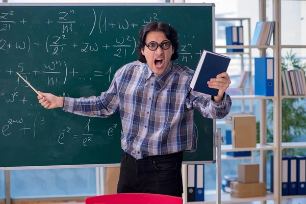 Young funny math teacher in front of chalkboard — Stock Photo, Image
