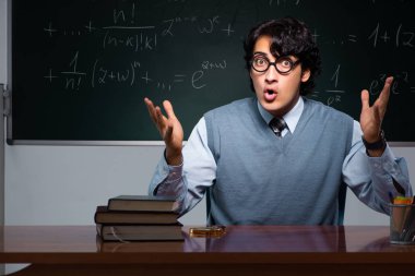 Kara tahta önünde genç matematik öğretmeni