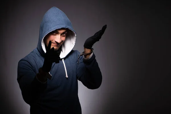 Joven gángster en capucha sobre fondo gris — Foto de Stock