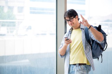 Genç yakışıklı öğrenci pencerede duruyor. 