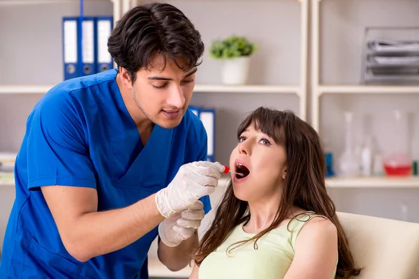 Médico recibiendo muestra de la prueba de saliva en el hospital clínico — Foto de Stock