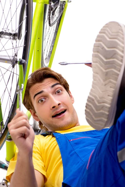 Hombre reparando su bicicleta aislado sobre fondo blanco — Foto de Stock