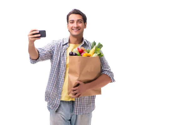 Joven con su tienda de comestibles en blanco —  Fotos de Stock