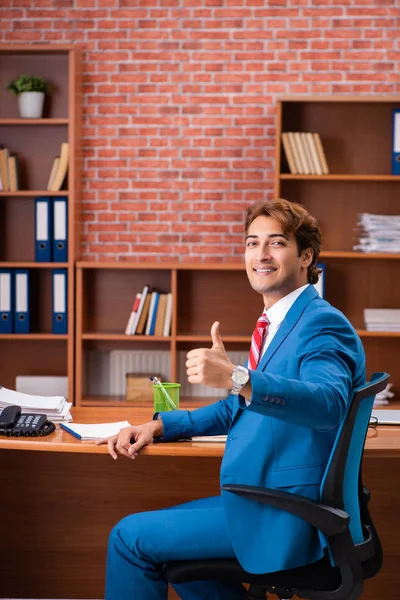 Joven empleado guapo sentado en la oficina — Foto de Stock